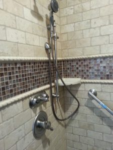 Mosaic glass detail in the owner's suite shower. The newly installed grab bar is visible on the right and adjustable height and hand held shower options are accessibility enhancements that can benefit anyone who may be having a bad day.