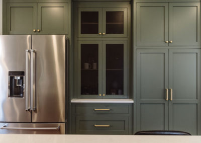 knocked down wall to connect kitchen and dining space made room for this wall of custom cabinetry in Benjamin Moore's Vintage Vogue green.