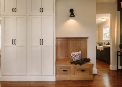 A pair of tall built in armoire-style cabinets are on the opposite side of the wall dividing the kitchen and front living room, facing the front door allowing coat and shoe storage.