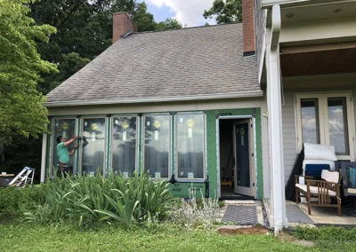 Paul works to secure the exterior sunroom with a vapor barrier, and flashing from the elements.